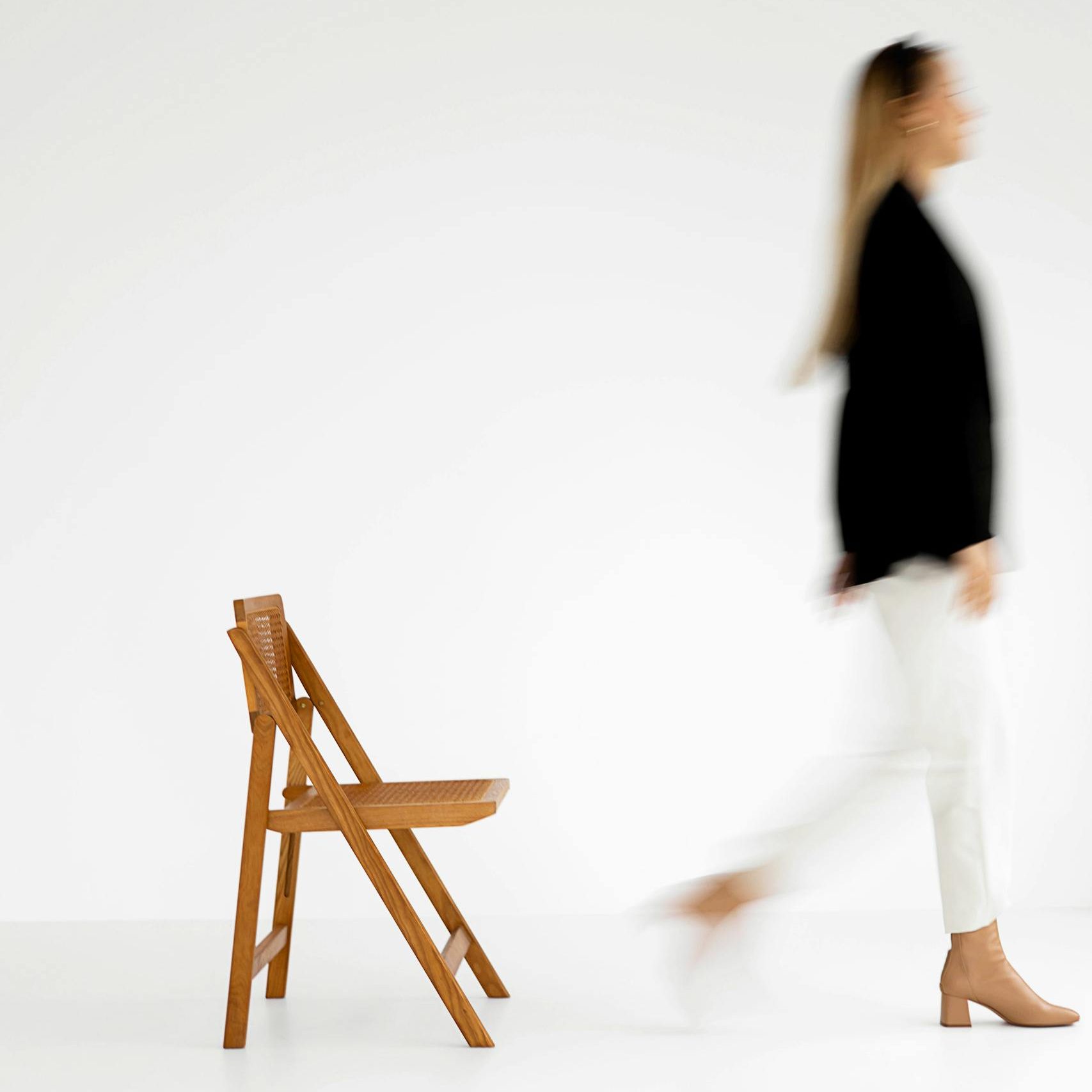 Blurred motion of a woman in black and white against a minimalist background.
